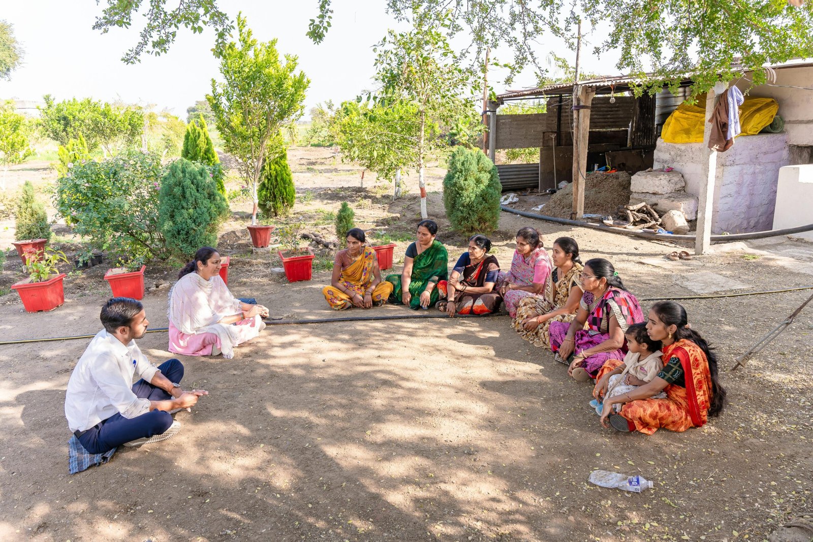 A diverse group gathered for a community meeting in rural Nagpur, India, discussing agriculture.